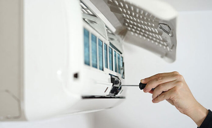 HVAC technician repairing an air conditioner unit