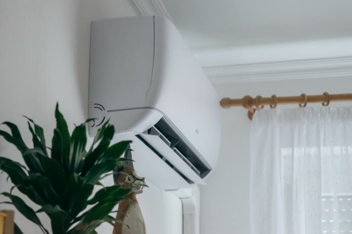 Ductless air conditioner mounted on the wall with remote control and modern interior design.